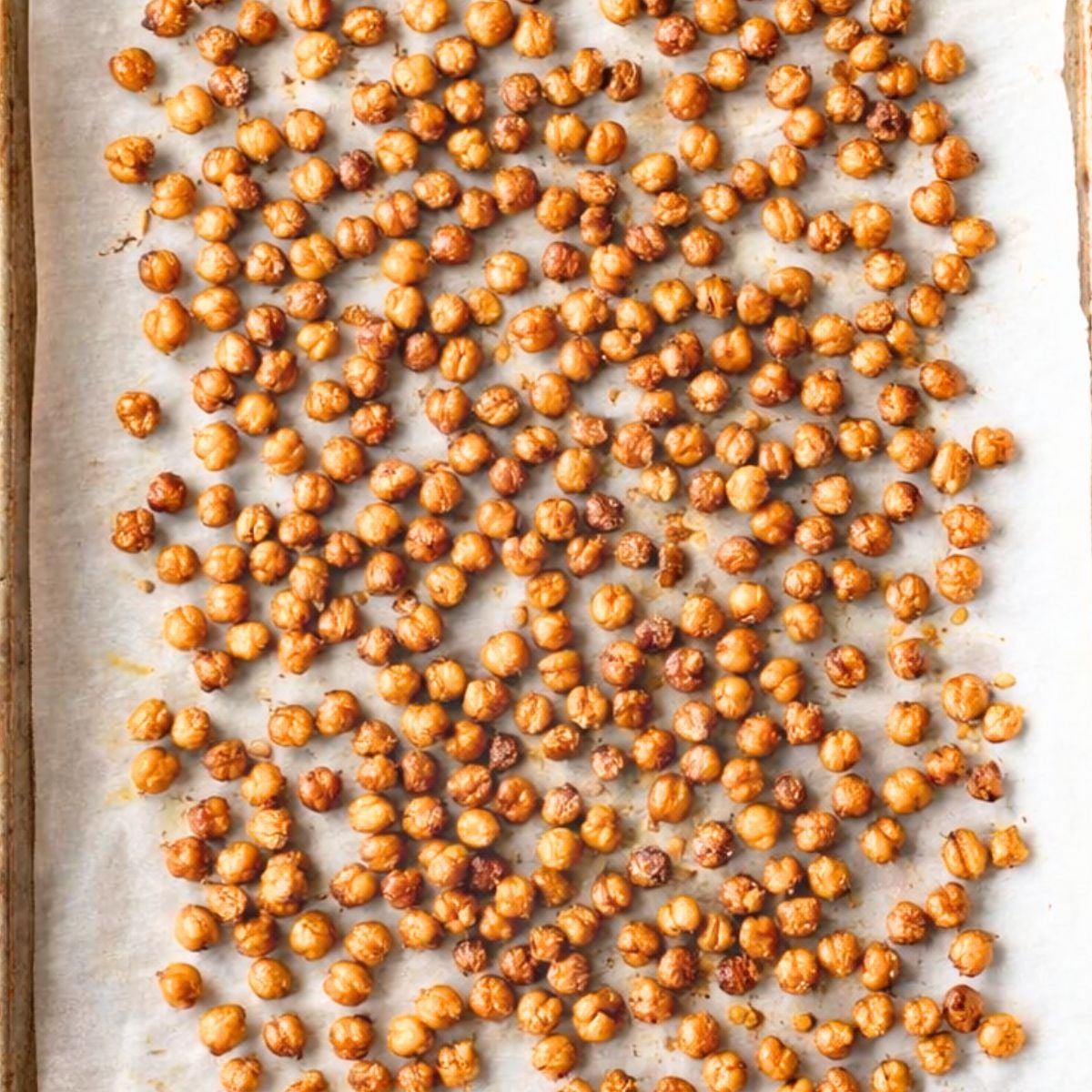 Golden roasted chickpea croutons cooling on a parchment-lined baking sheet.