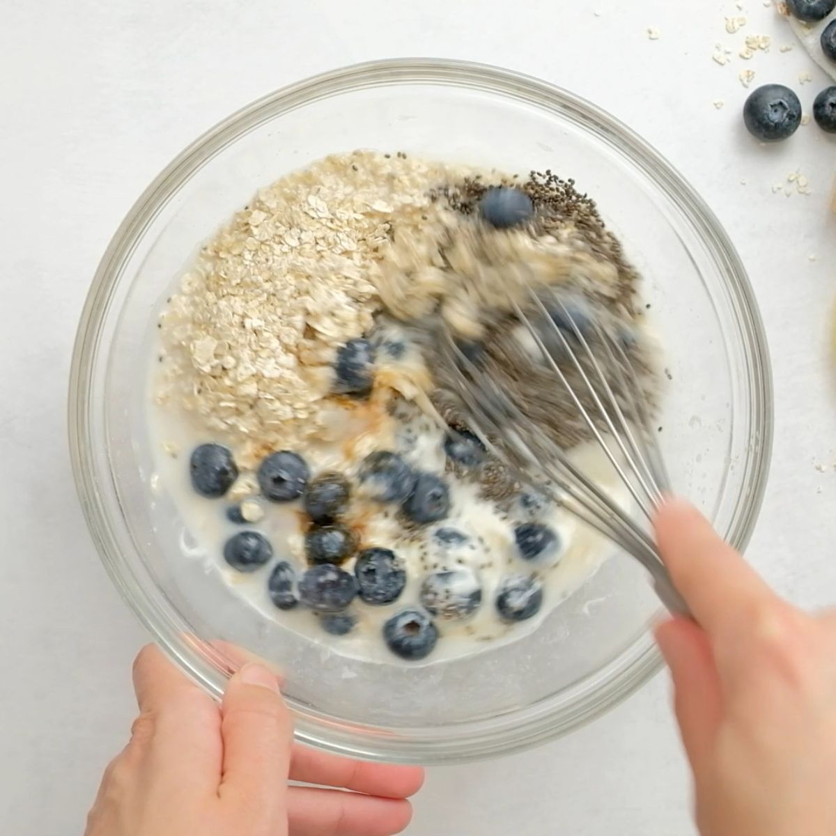 Whisking blueberry overnight oats in a bowl