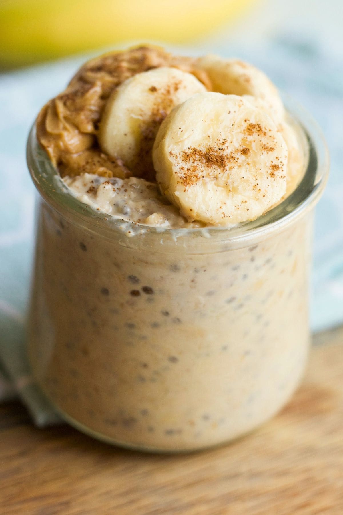 Jar of peanut butter banana overnight oats on a cutting board