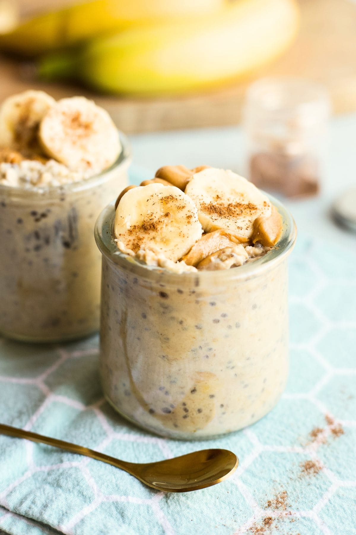 Jars of peanut butter banana overnight oats sit on a tabletop