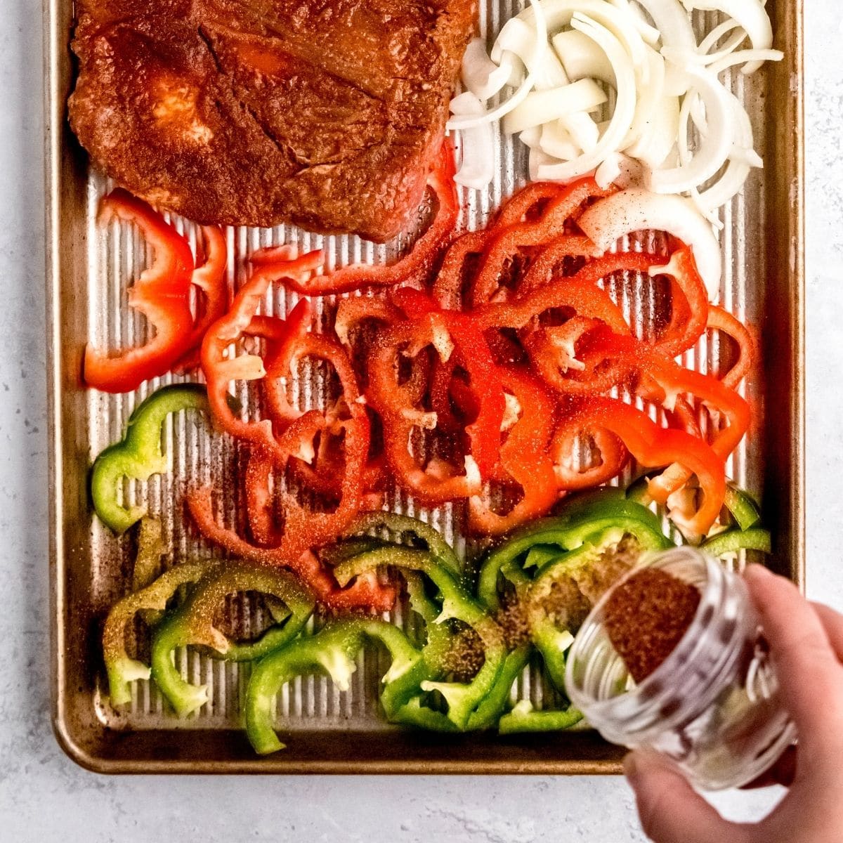 Seasoning fajita peppers on a sheet pan
