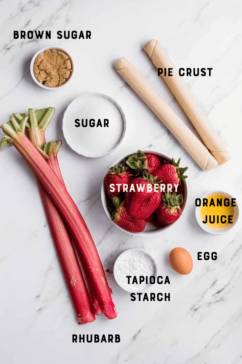 Ingredients labeled and laid out, including pie crust, rhubarb, strawberries, orange juice, tapioca, sugar, and brown sugar.