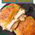 Close view of two baked sliders on a dark plate. A text overlay reads, "Ham & Swiss Baked Sliders."