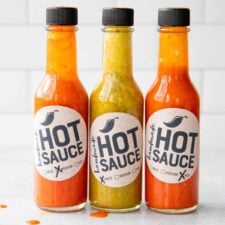 Three bottles of from my hot sauce recipe, lined up on a counter.
