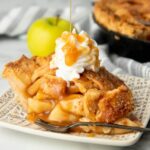 Caramel gets drizzled over a slice of a pie on a patterned plate