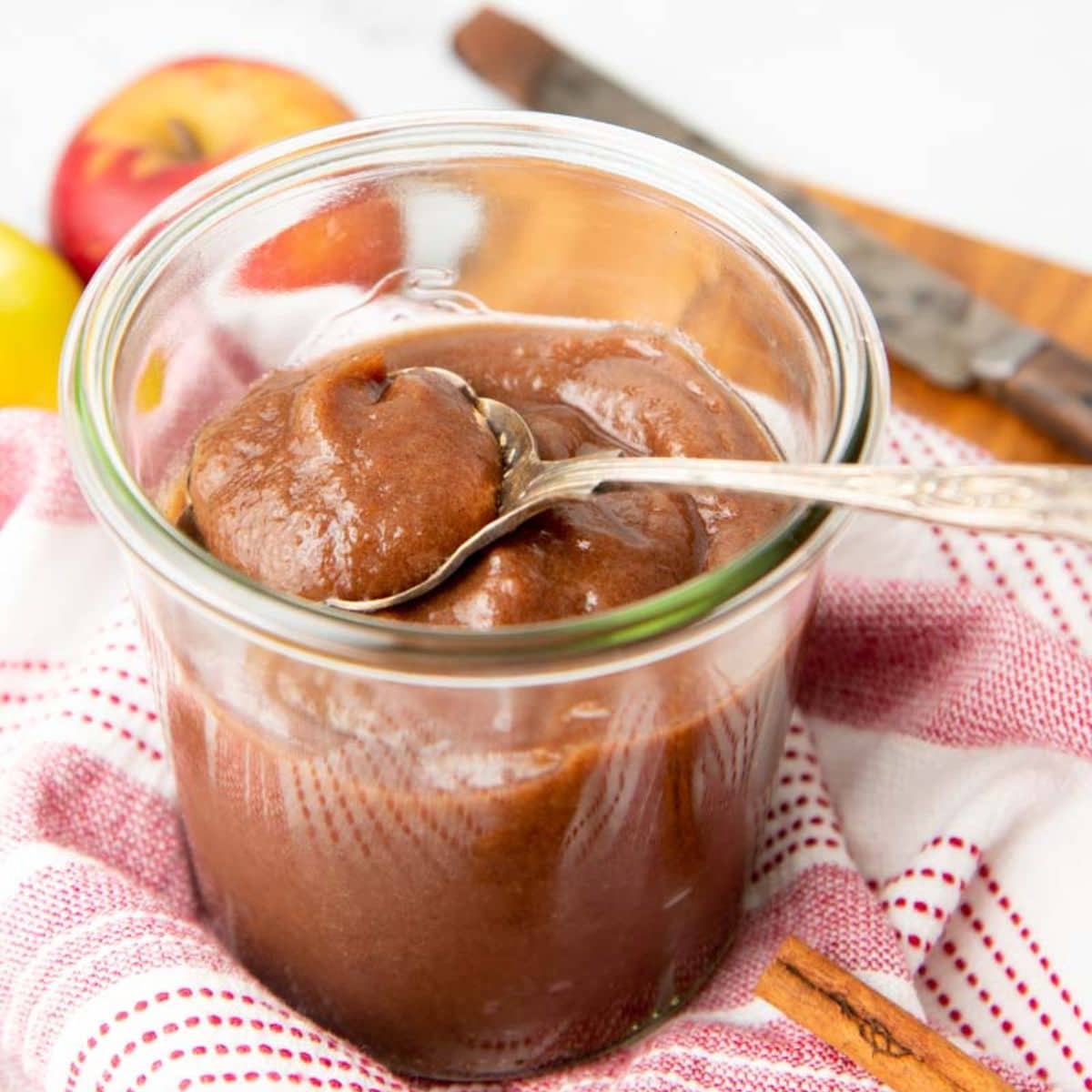 A spoon dips into a jar of Instant Pot apple butter