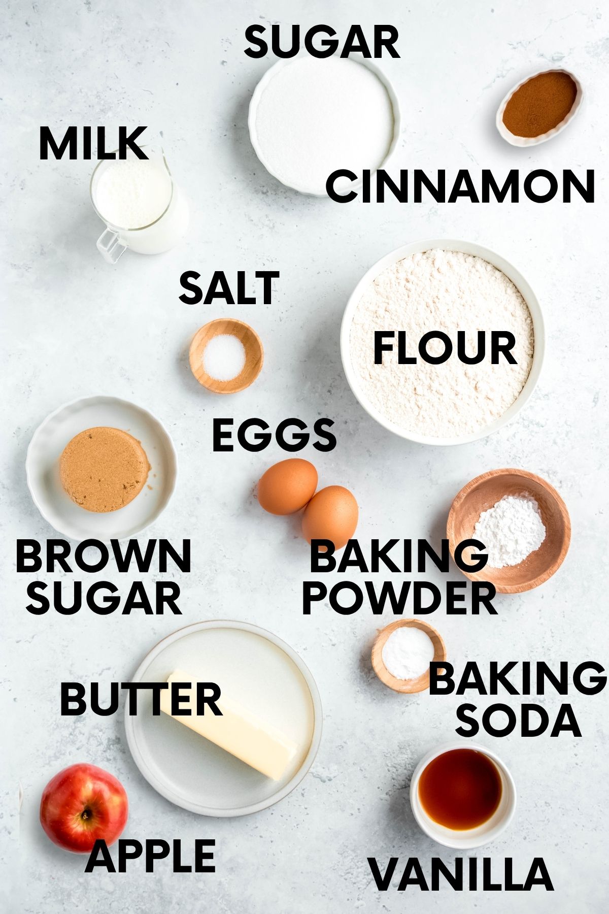 Ingredients for an apple cinnamon muffin recipe: flour, milk, sugar, cinnamon, salt, brown sugar, eggs, baking powder, baking soda, butter, apple, vanilla.