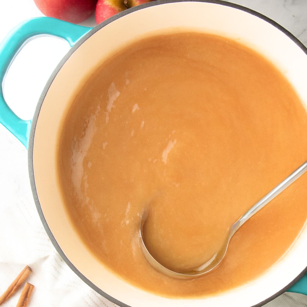 A ladle stirs the liquid for canning apple pie filling.