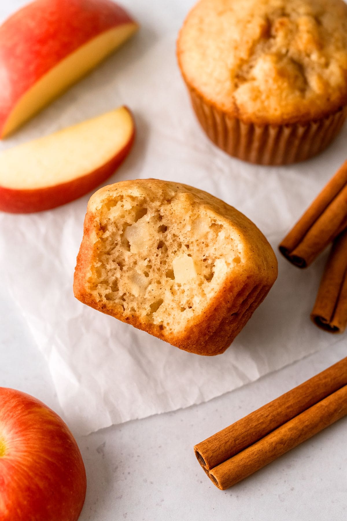 A muffin with a bite taken out of it, revealing the apple chunks inside.