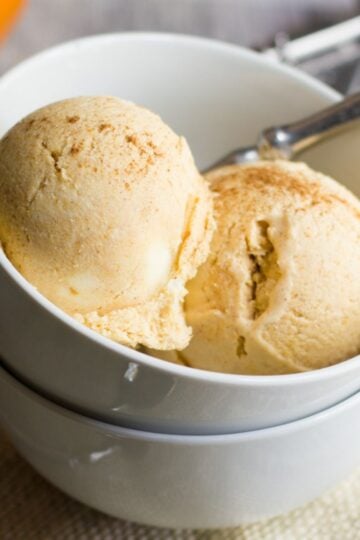 Two scoops of homemade pumpkin ice cream in a white bowl