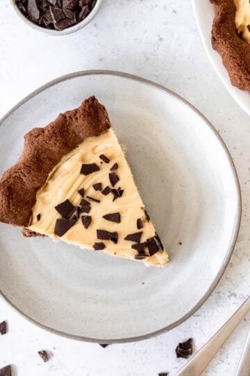 A slice of chocolate peanut butter pie on a plate next to two forks.