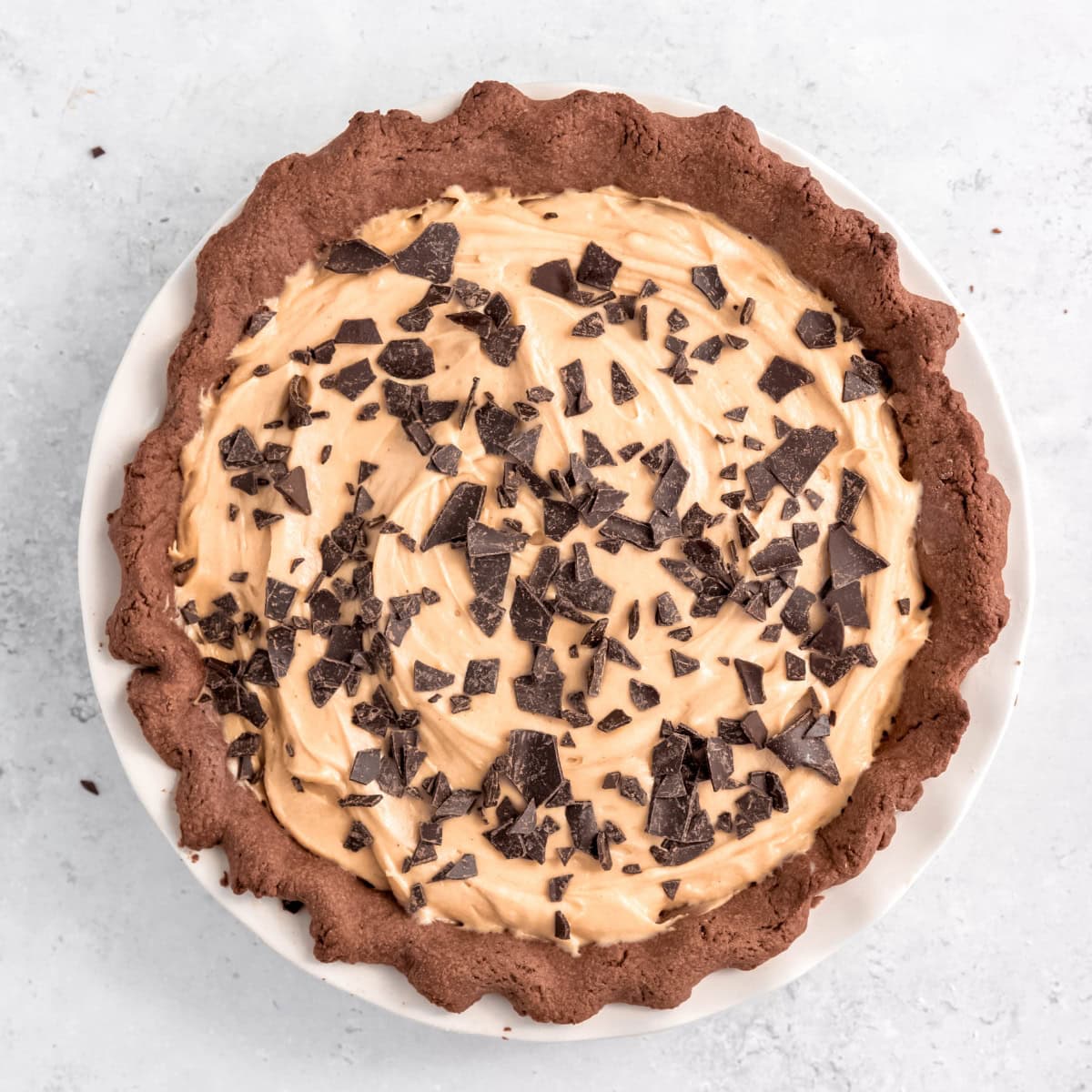A finished chocolate peanut butter pie topped with chocolate shavings.
