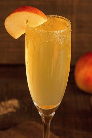 Apple cider mimosa with a brown sugar rim and an apple slice garnish