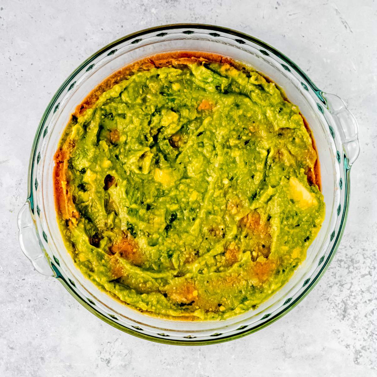 Guacamole in an even layer in a pie pan
