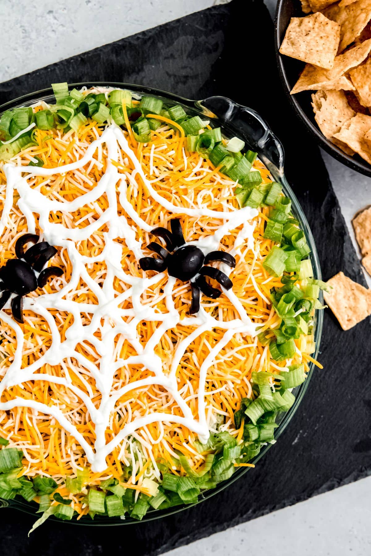 Halloween taco dip with a sour cream "spider web" on top