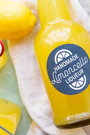 A labeled bottle of homemade limoncello on a white tea towel.