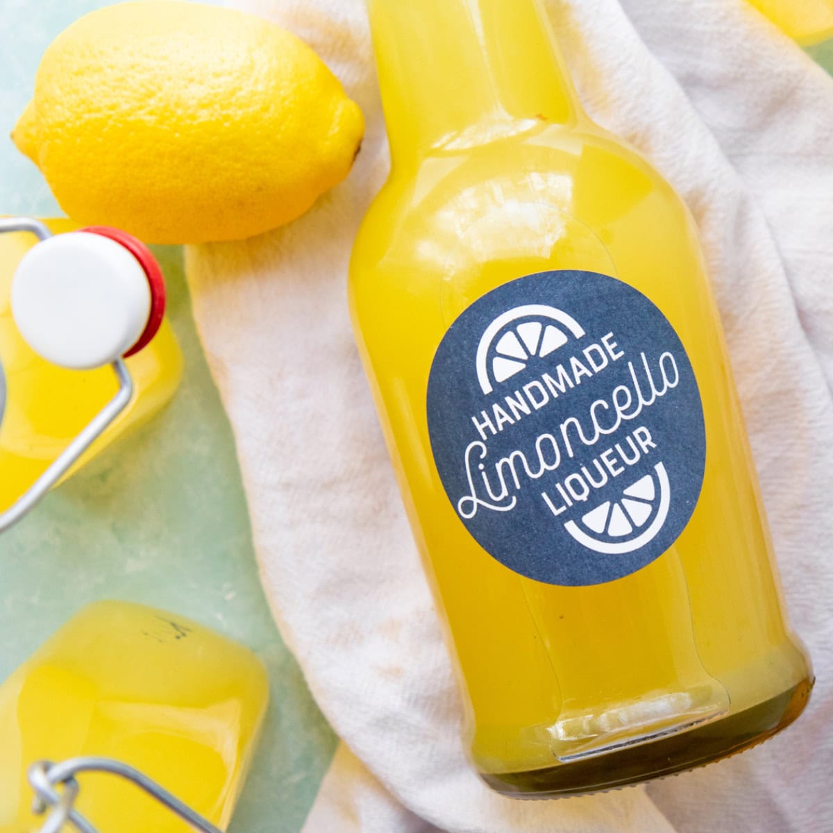 A labeled bottle of homemade limoncello on a white tea towel.