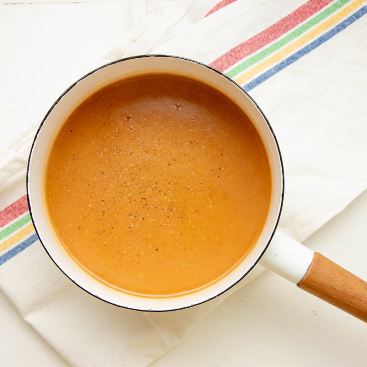 Homemade turkey gravy seasoned with salt and pepper, in a pot.
