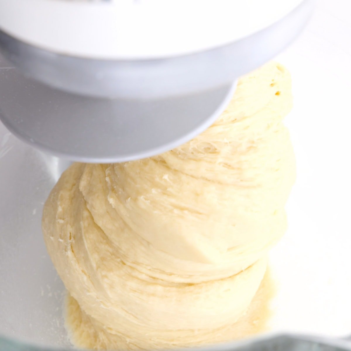Yeast dough starting to come together in a stand mixer.