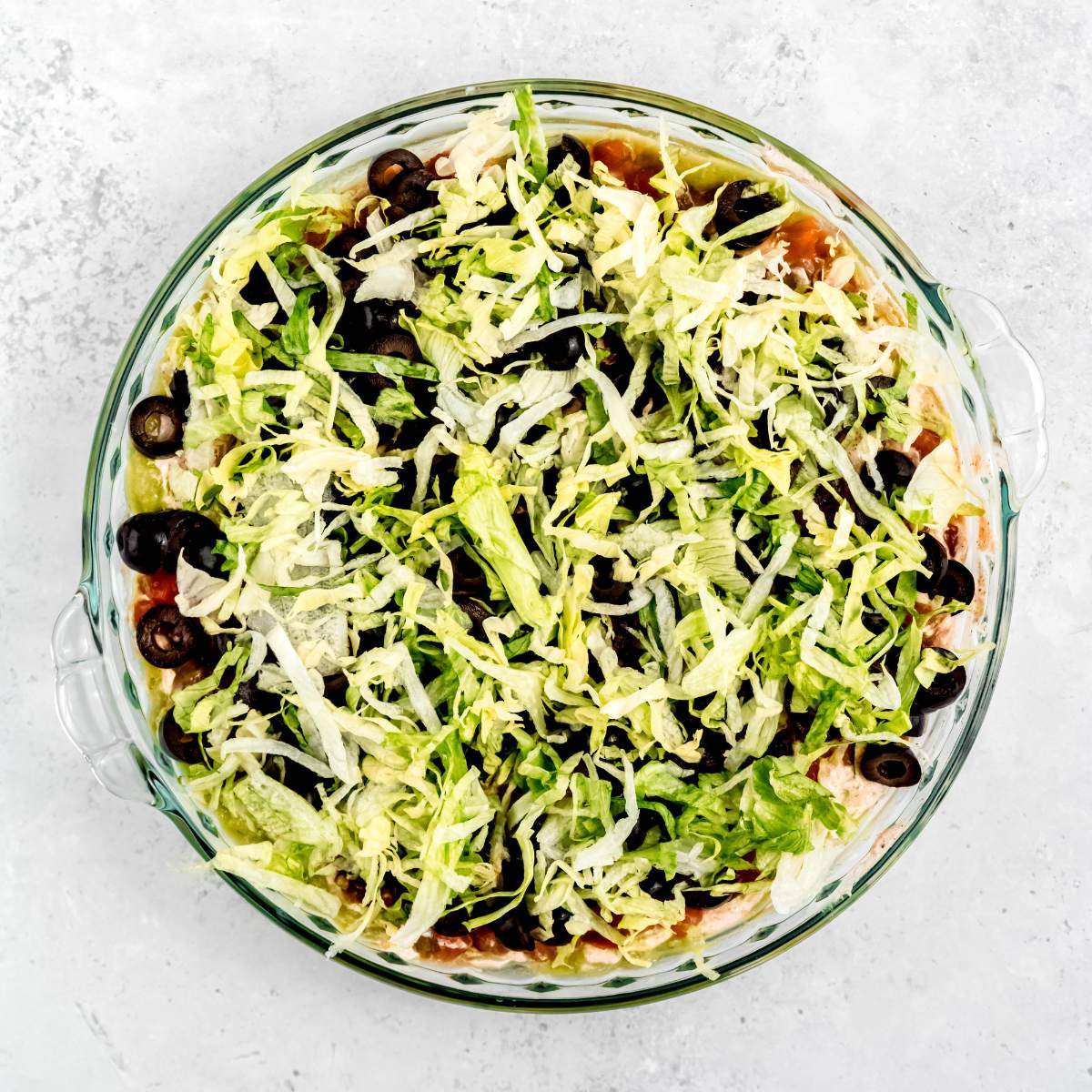 Shredded lettuce in an even layer in a pie pan