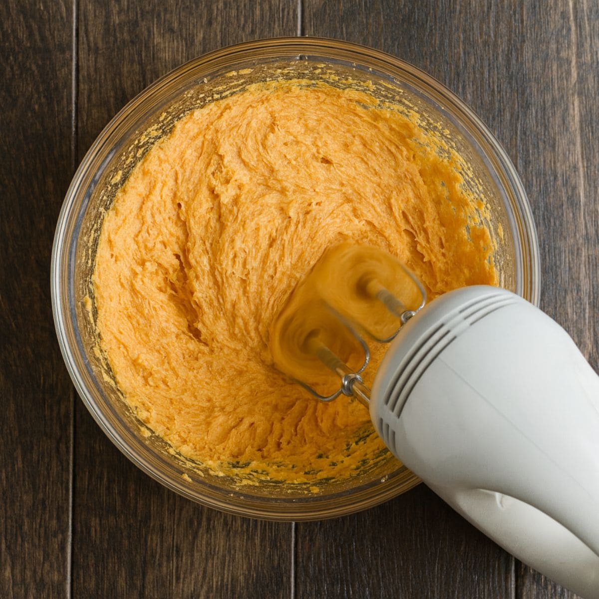 Electric mixer in a bowl of pumpkin filling