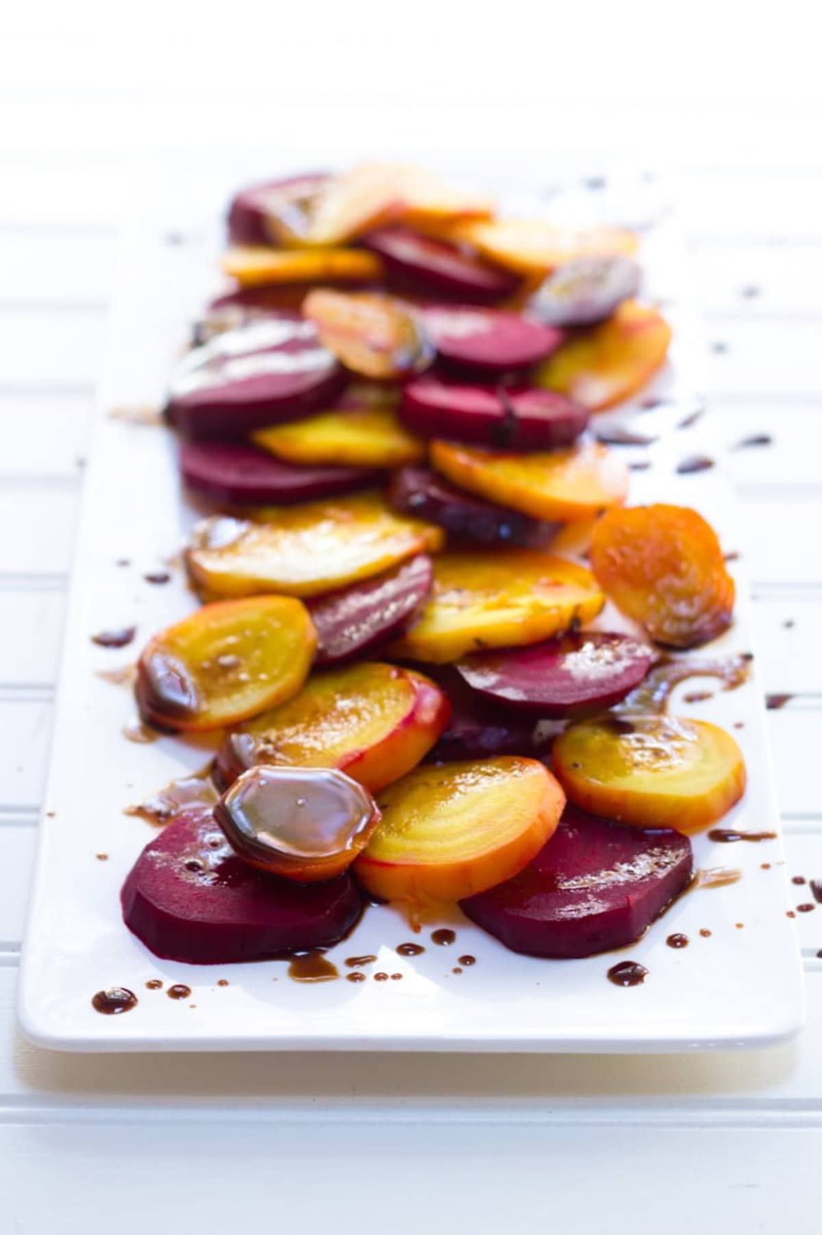 Balsamic roasted beets arranged on a long white platter.