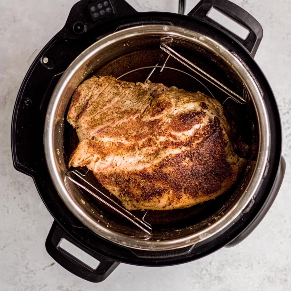 A seared pork shoulder in an Instant Pot.