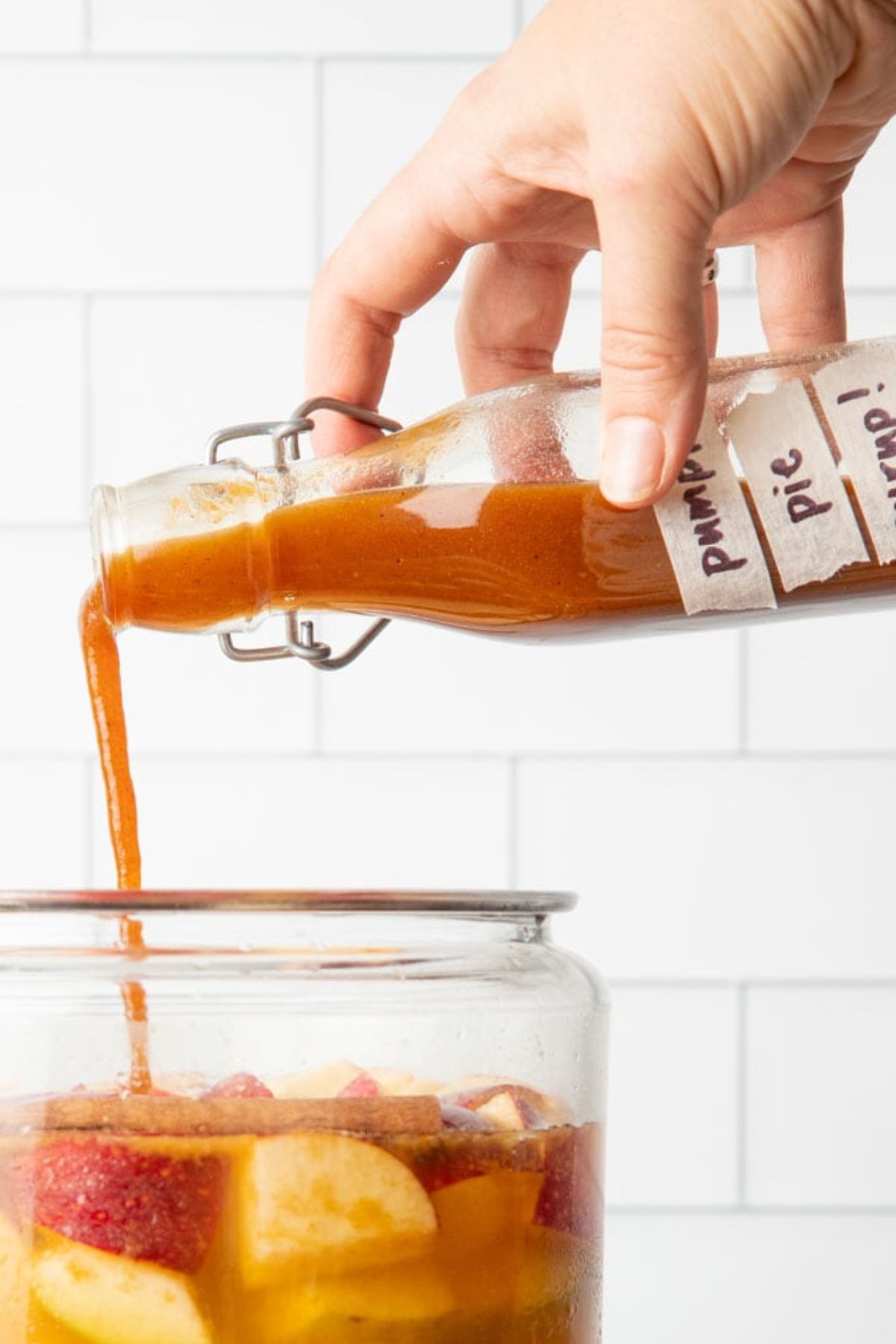 Pumpkin syrup pours into a jug of sangria