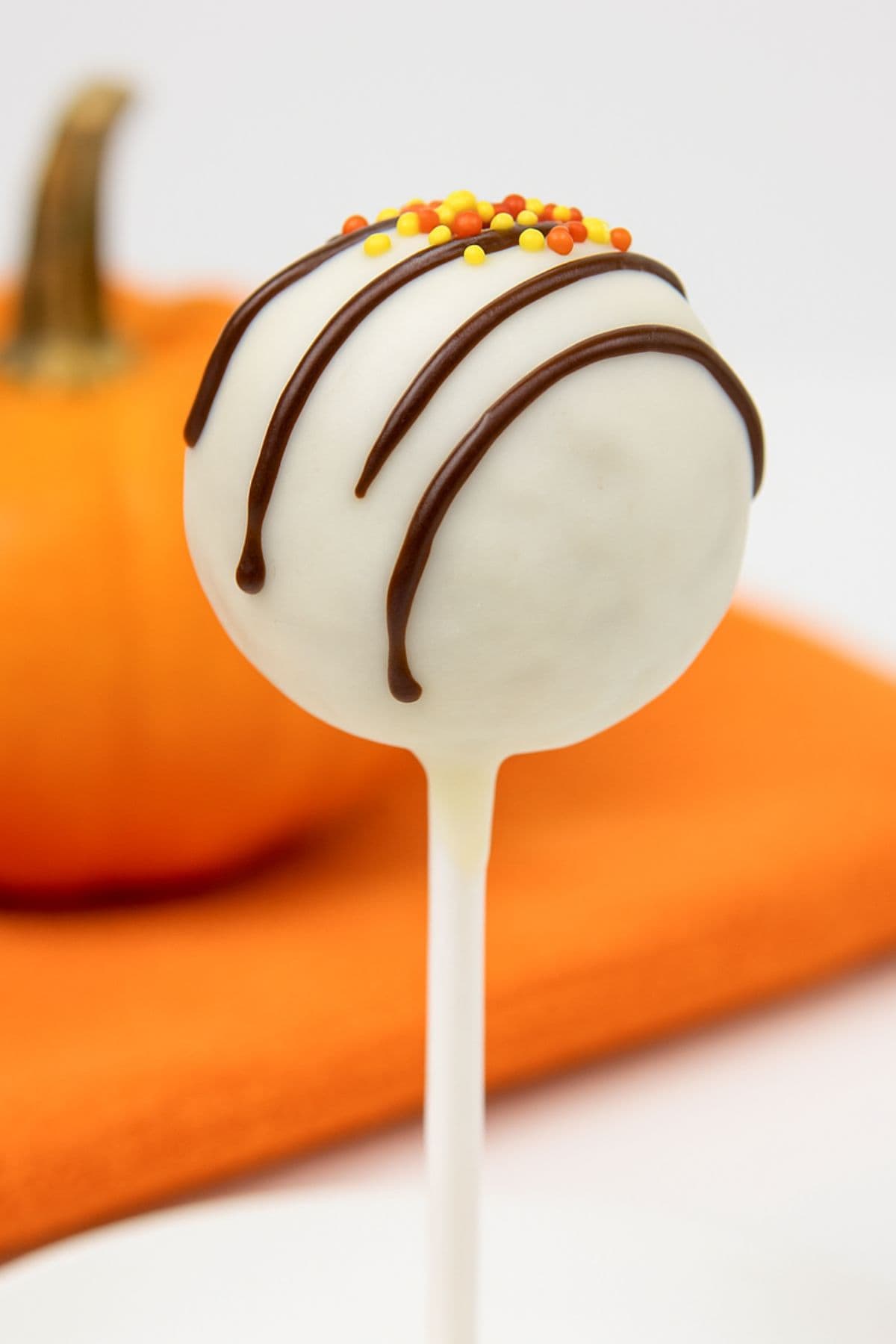 A single pumpkin cake pop with sprinkles