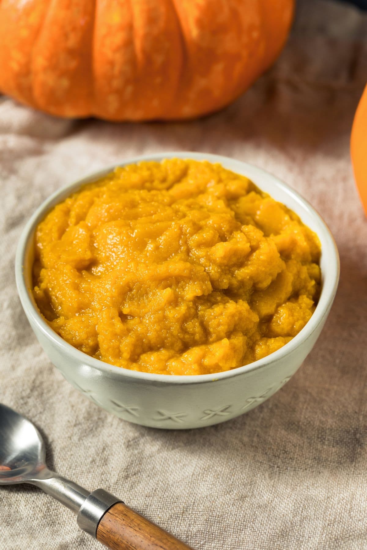 Homemade pumpkin puree in an off-white bowl.