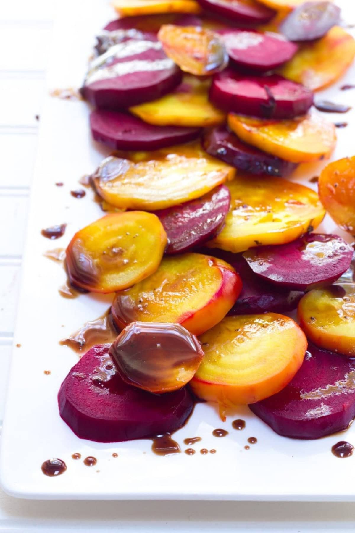 Balsamic roasted beets, both red and golden, on a white platter.