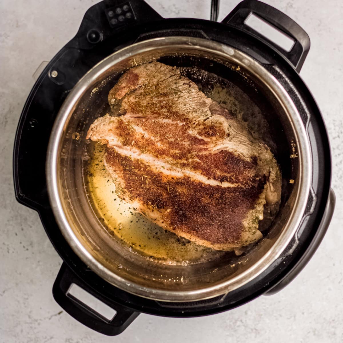 Searing a pork shoulder in an Instant Pot.
