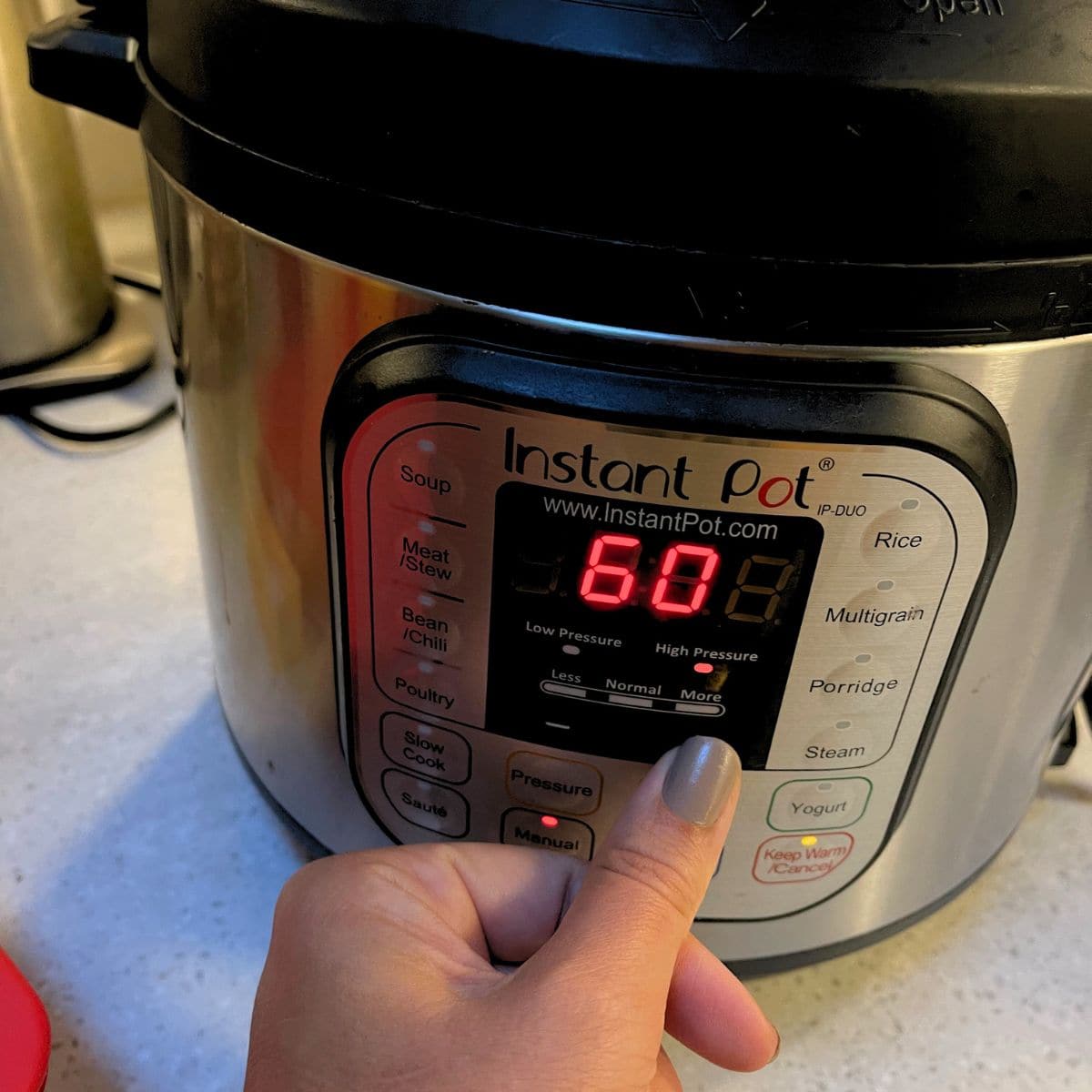 A hand sets the Instant Pot to high pressure