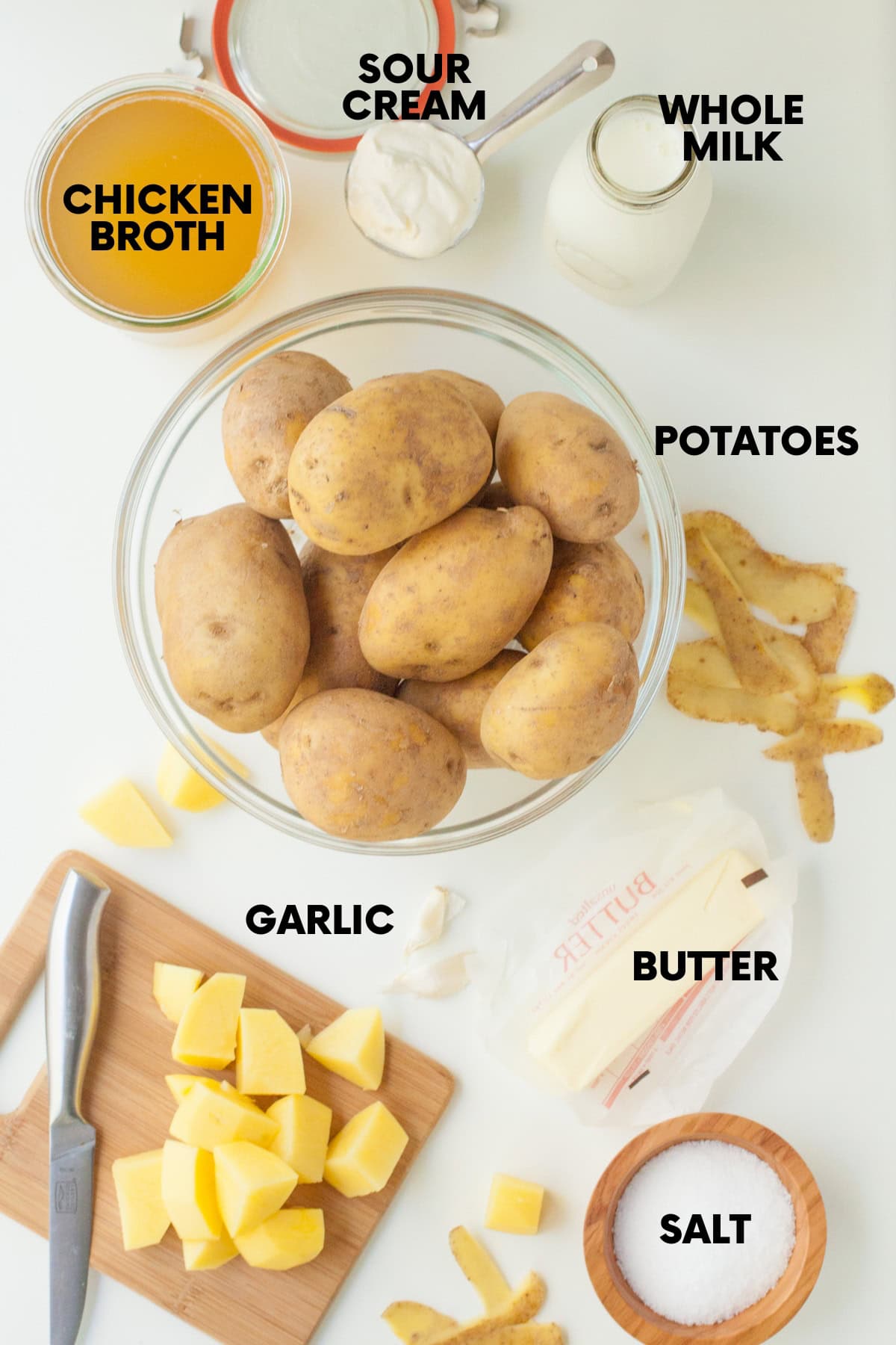 Ingredients for a slow cooker mashed potatoes recipe: potatoes, chicken broth, sour cream, whole milk, garlic, butter, salt.