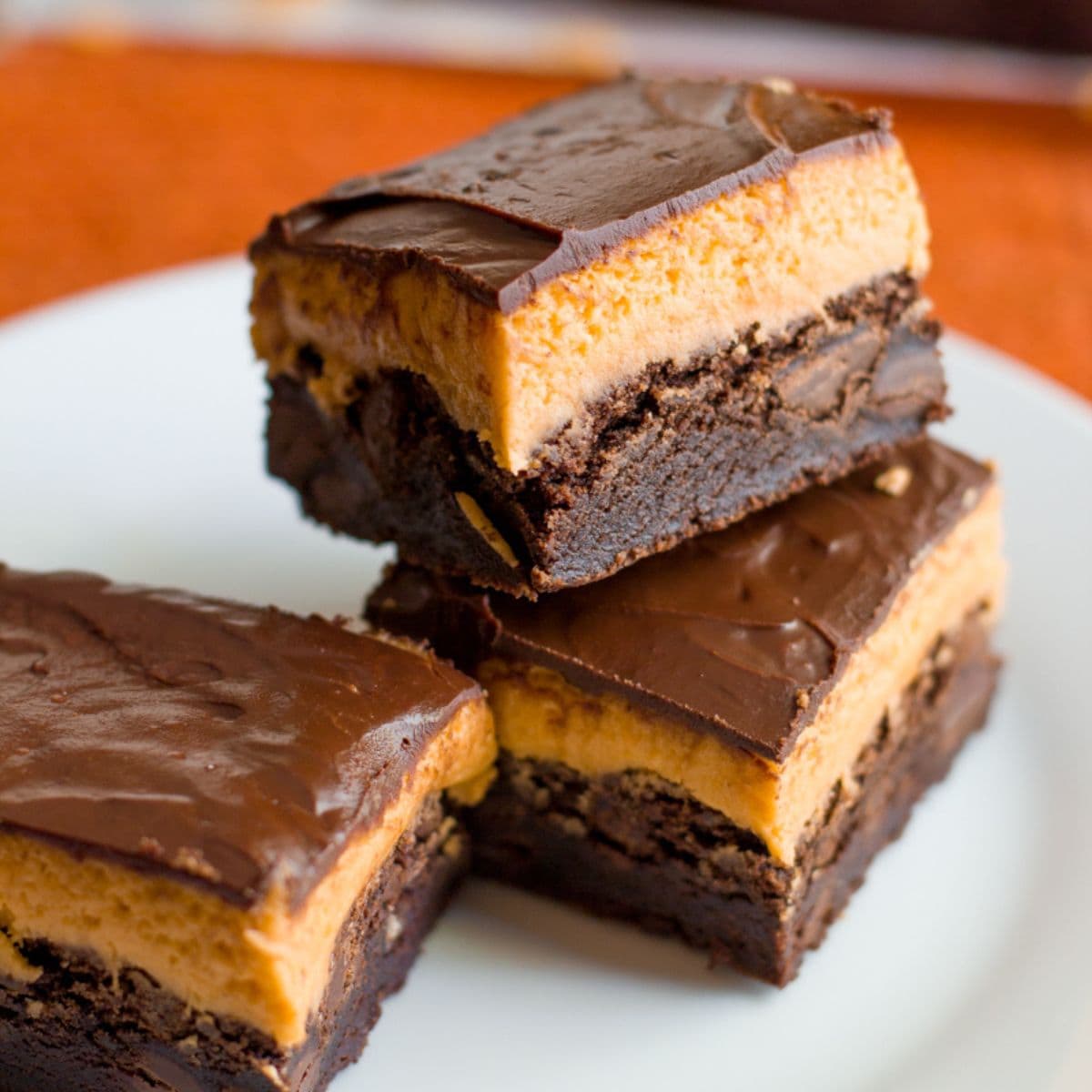 Stack of pumpkin brownies on a white plate