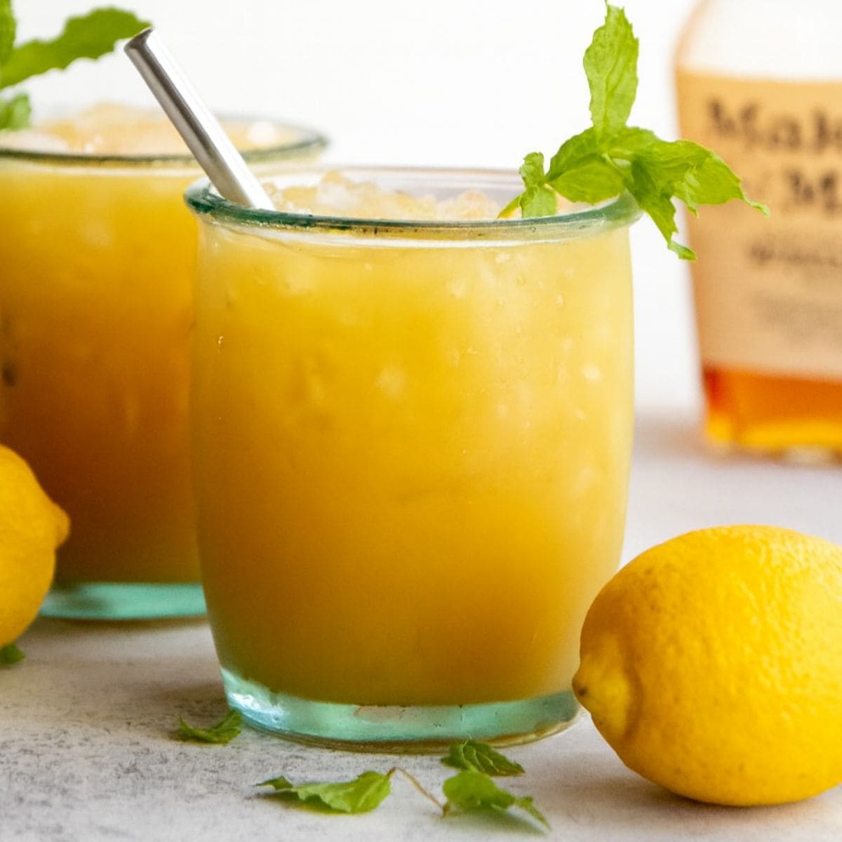 Glass of whiskey punch with crushed ice and a mint sprig.