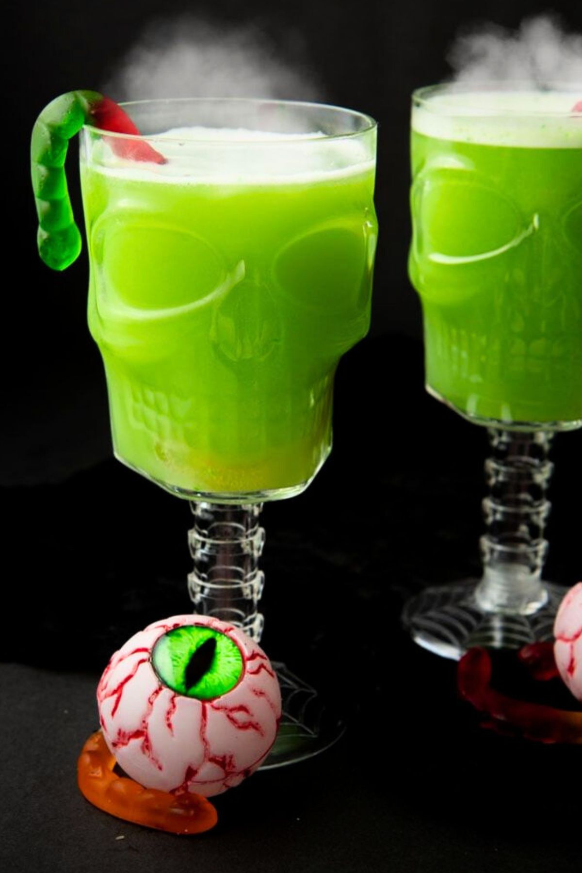 Two skull-shaped glasses filled with green punch
