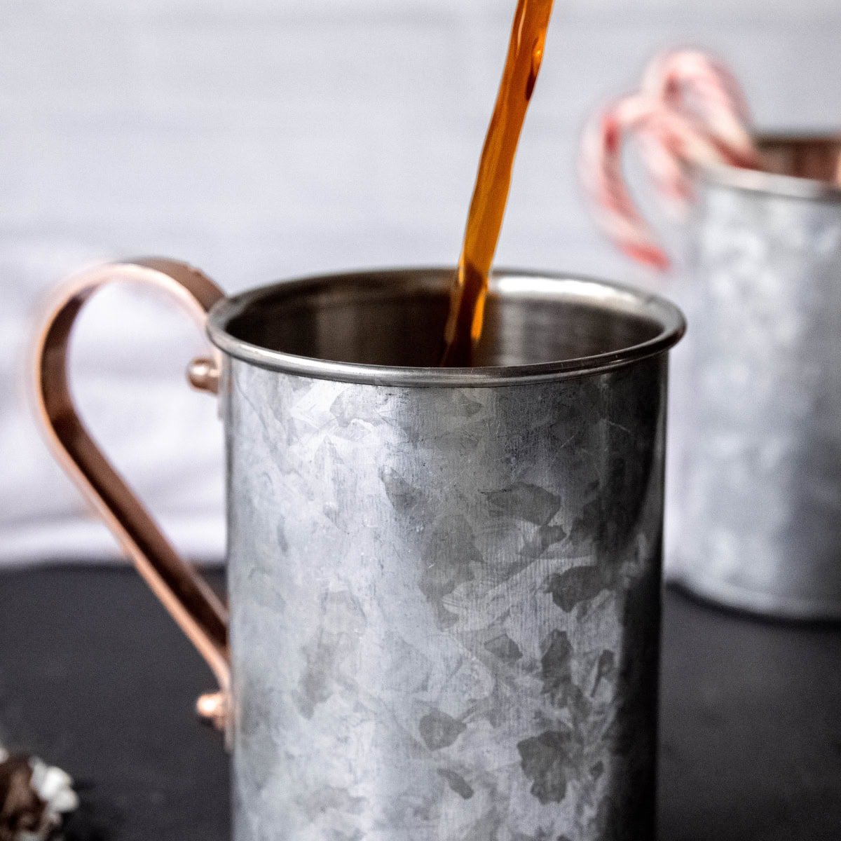 Espresso pours into a tin mug.