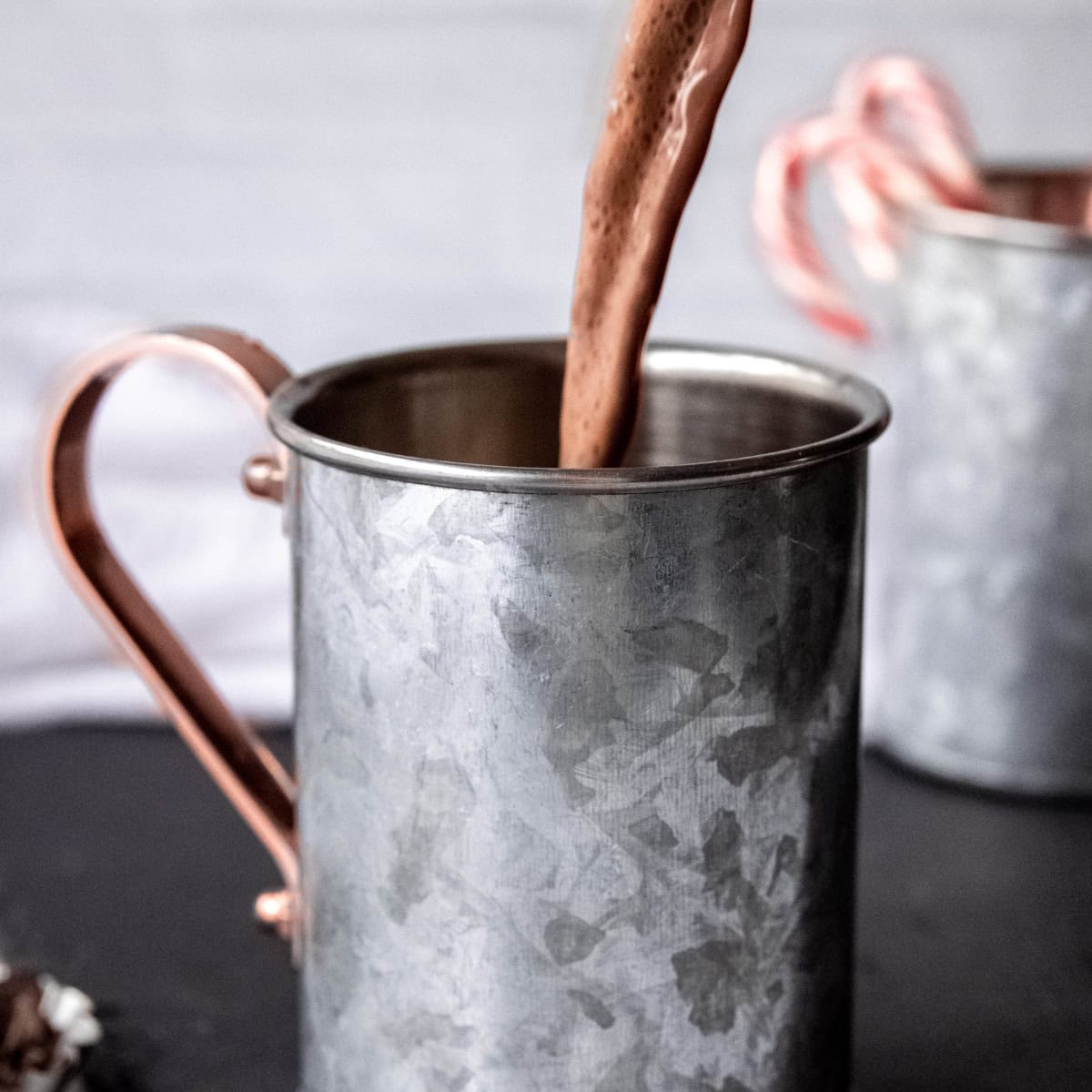 Peppermint mocha sauce pours into a tin mug.