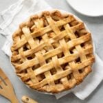 A baked apple pie with an all-butter pie crust, with a lattice top.