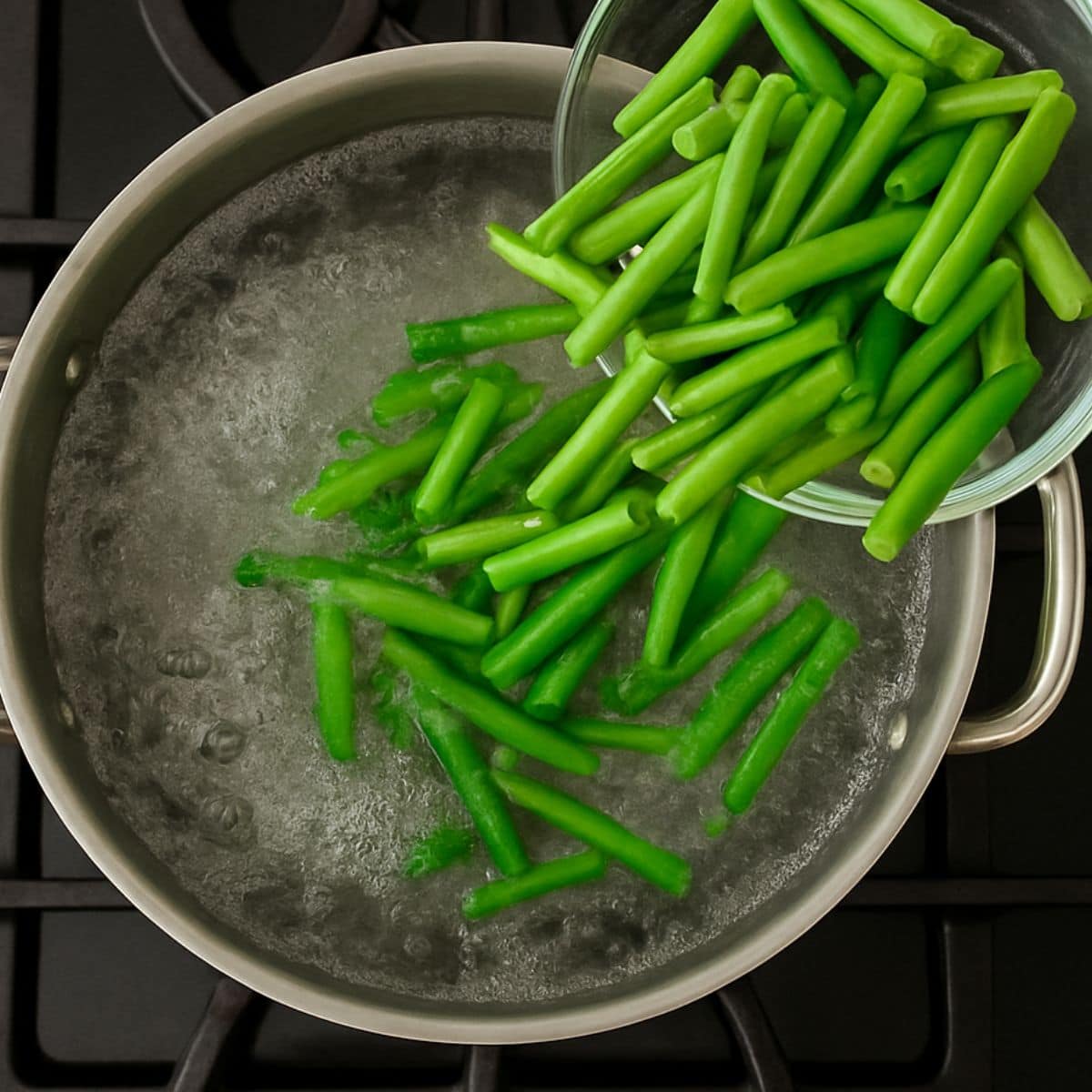 Fresh green beans pour into a pot of boiling water for blanching.