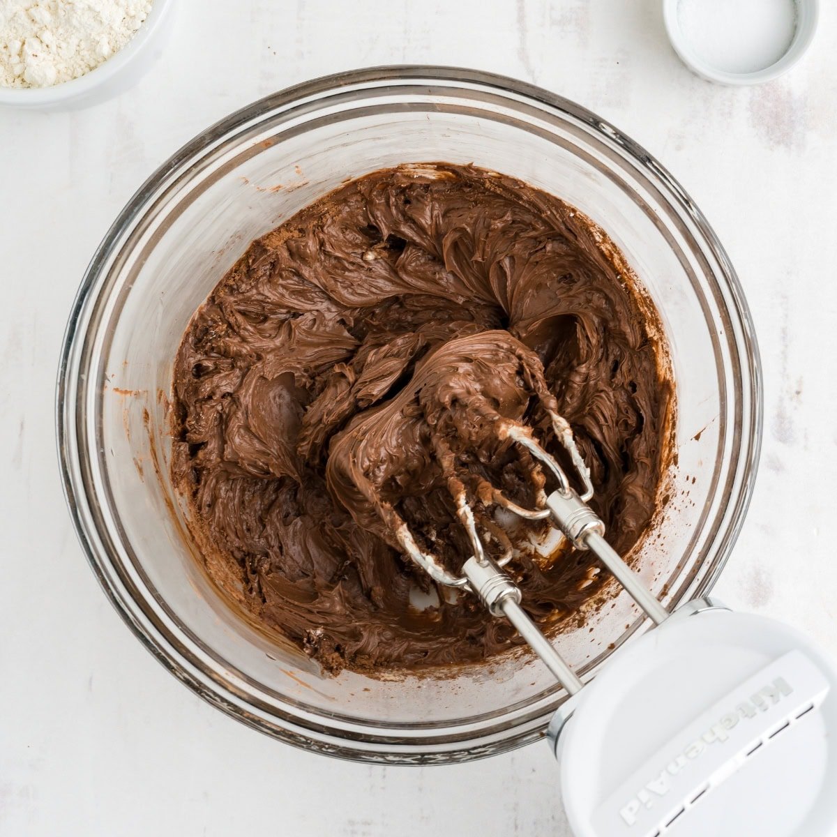 An electric mixer beats chocolate cookie dough.