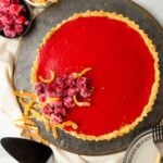 A cranberry curd tart on a dark gray tray.