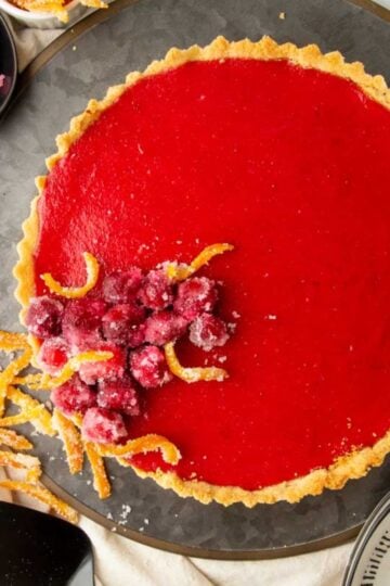 A cranberry curd tart on a dark gray tray.