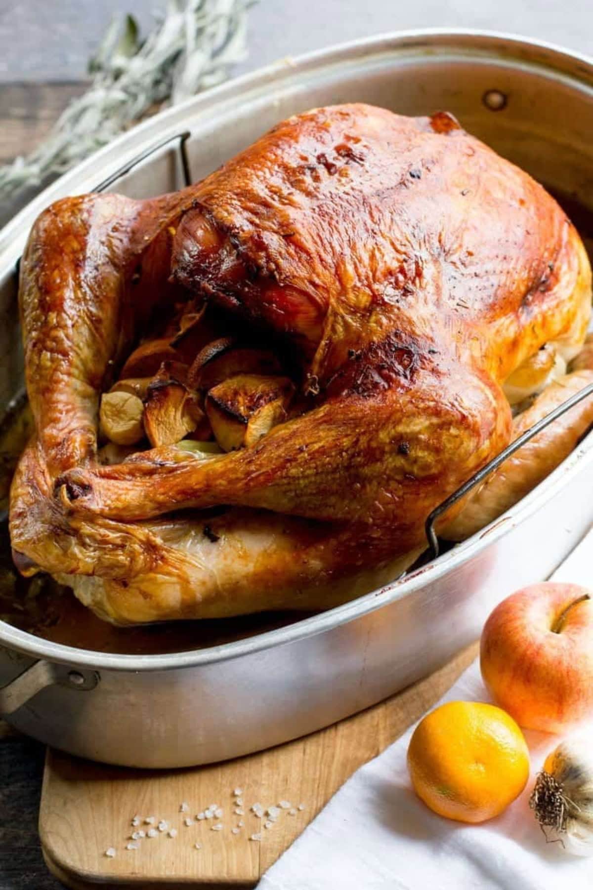 A dry brined turkey in a roasting pan after roasting.