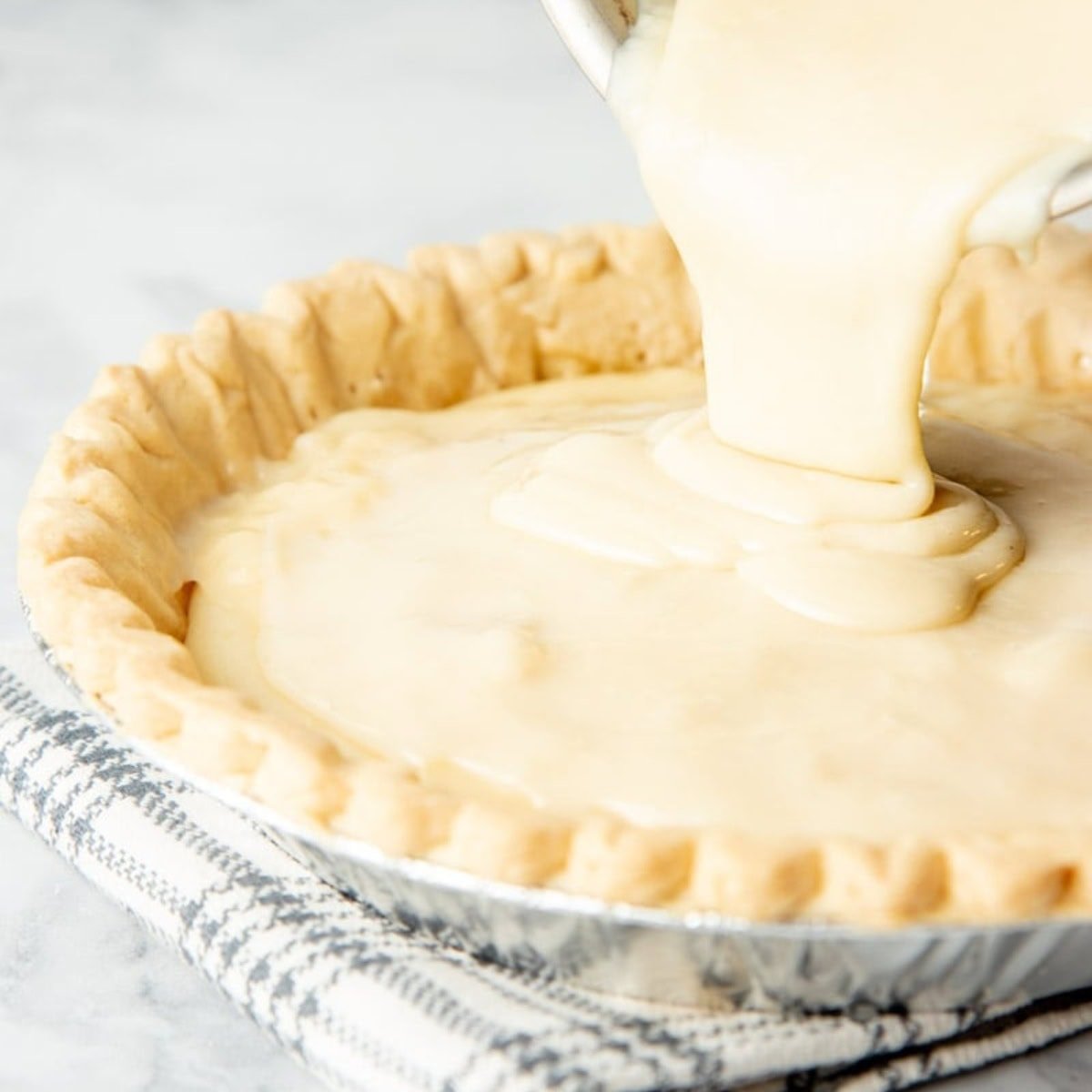 Sugar cream pie filling pours into a blind-baked pie shell.
