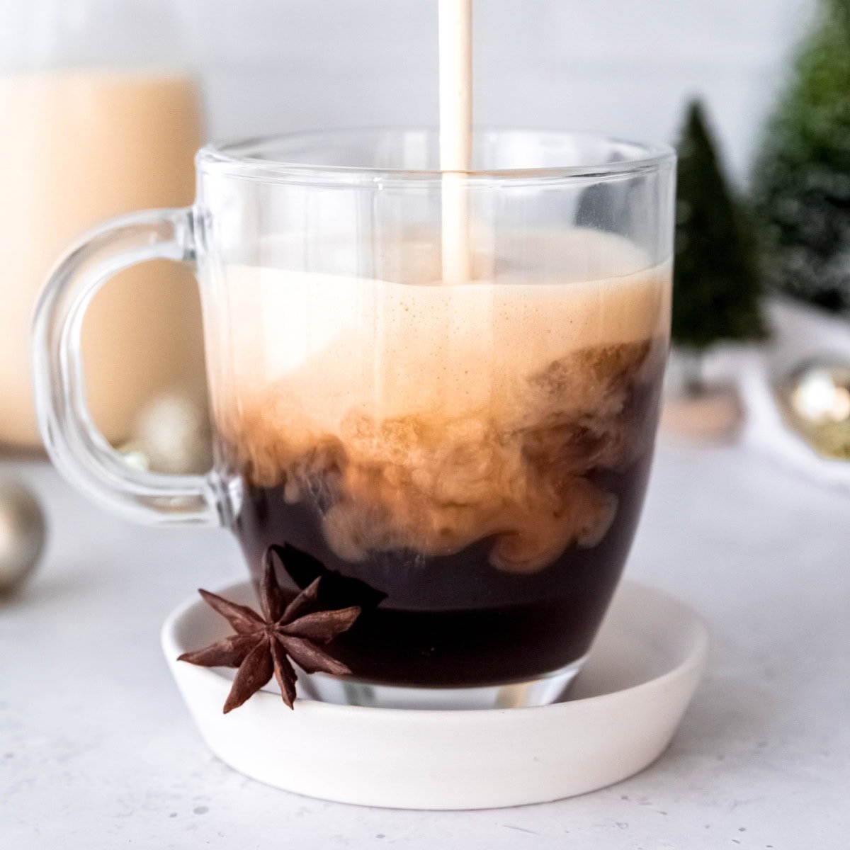 Frothed eggnog pours into a mug of espresso.