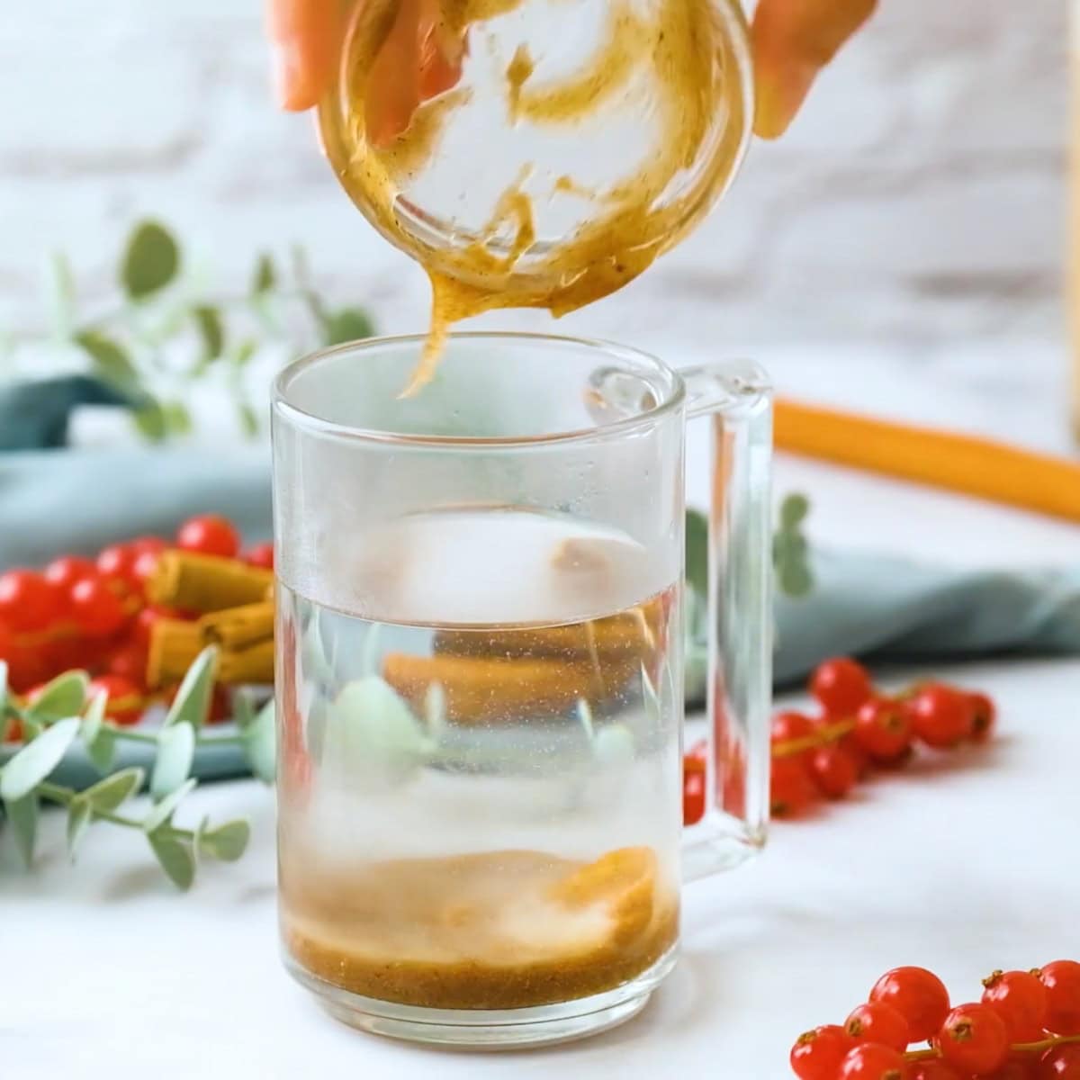 Adding batter for hot buttered rum to a mug of hot water.