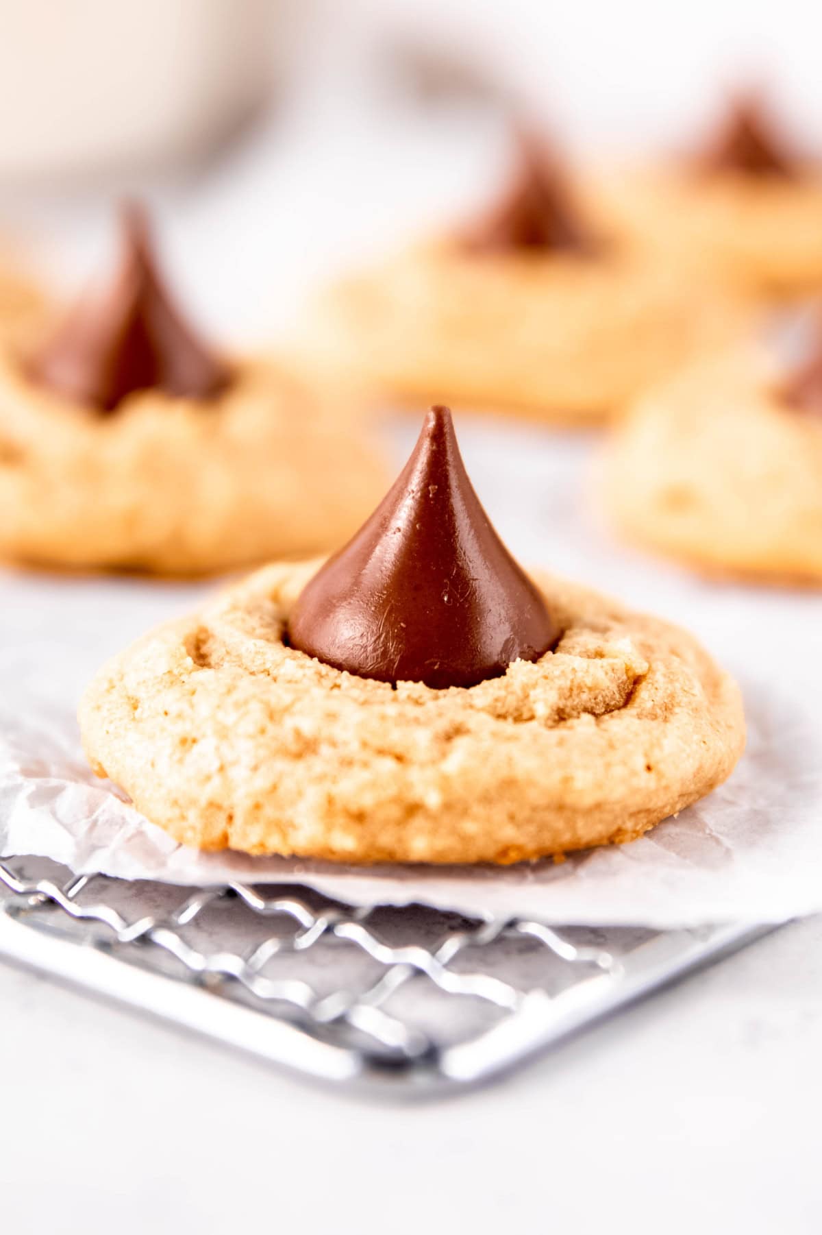 A peanut butter kiss cookie cools on a wire rack.