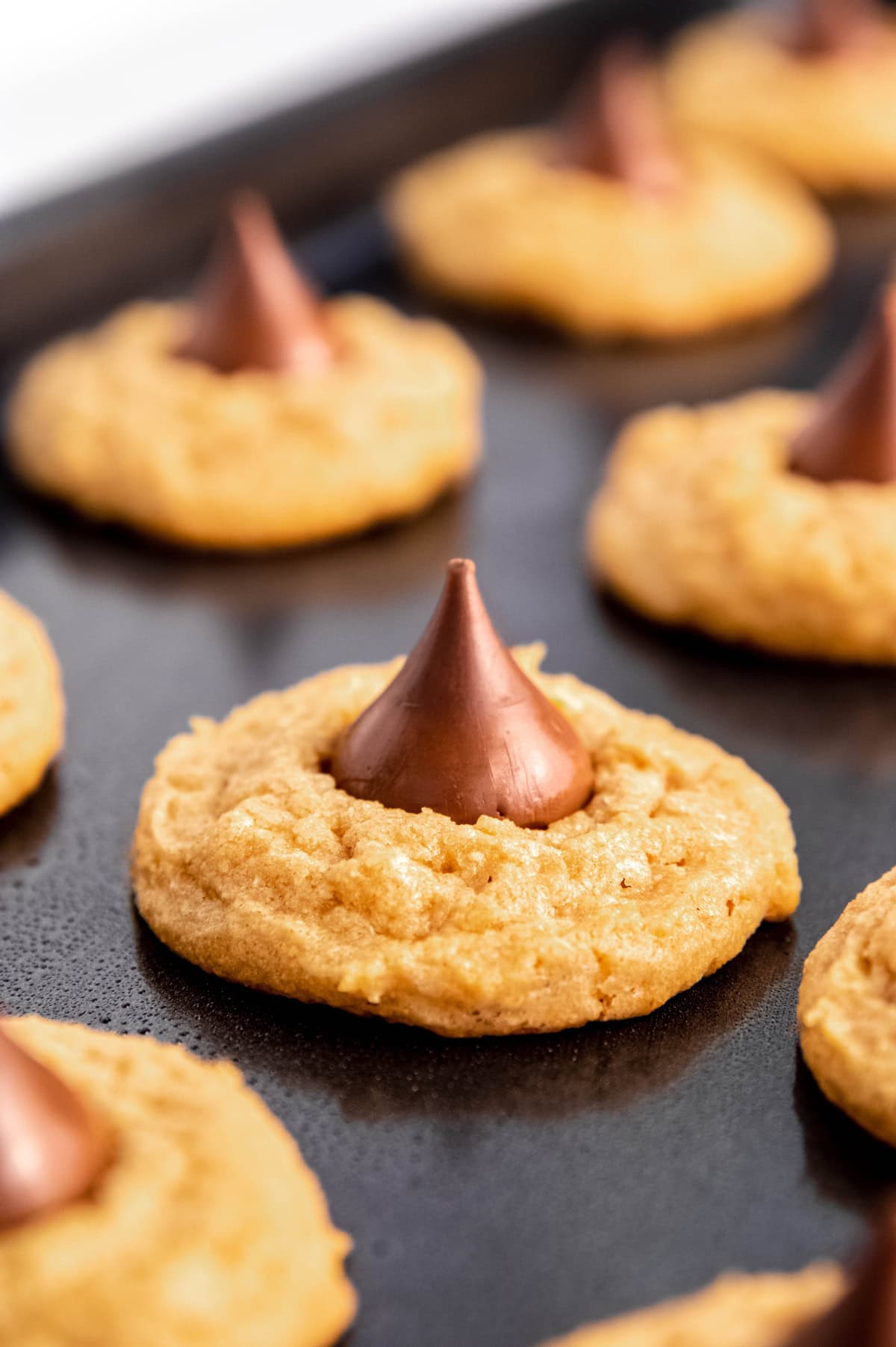 A baking sheet full of peanut butter kiss cookies.